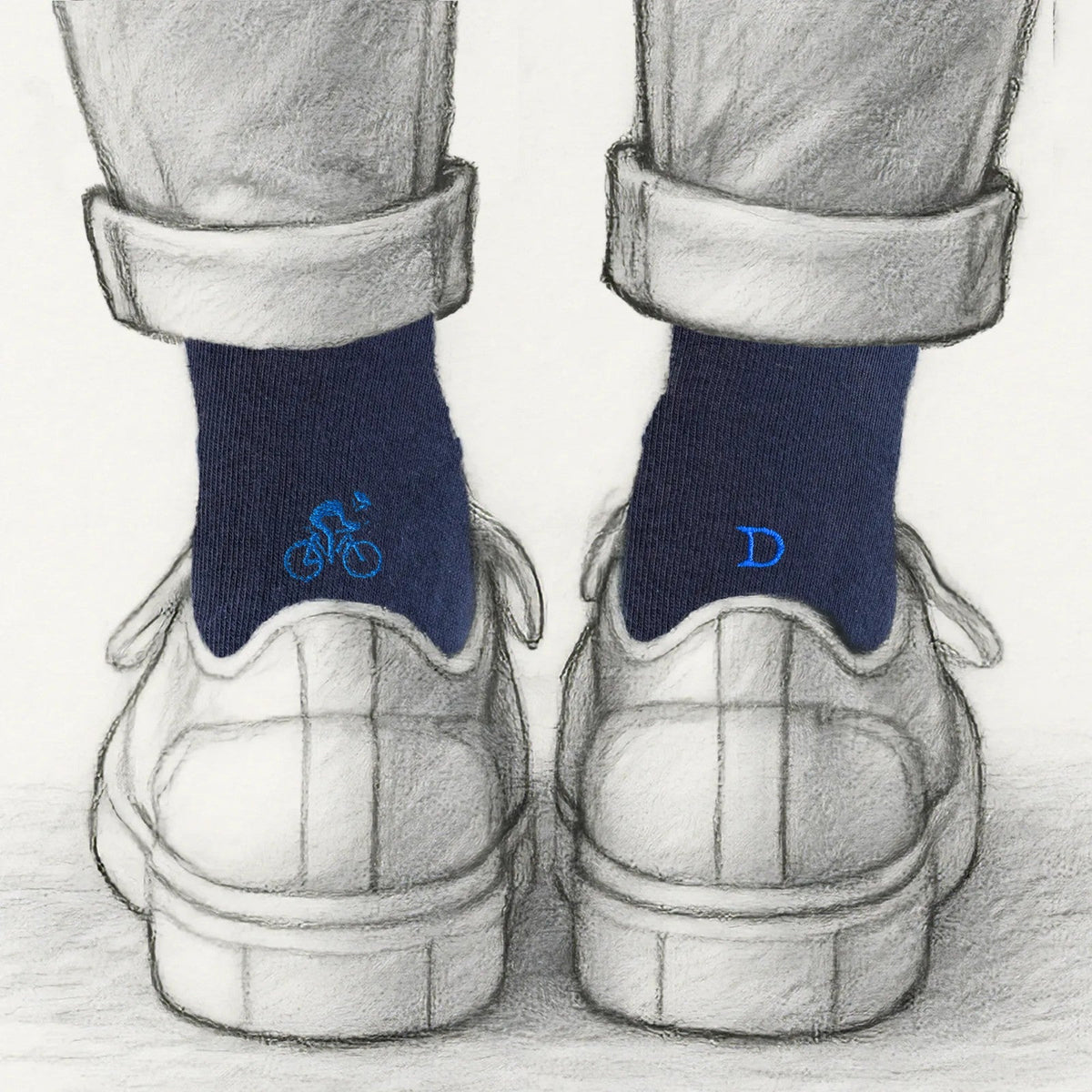 regalo per chi va in bici: calze blu Individual Socks con il ciclista ricamato in blu royal su una calza e l'iniziale sull'altra, viste da dietro
